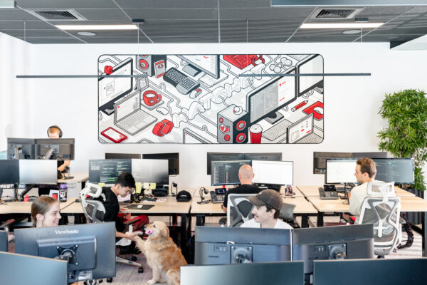 Full office shot of Hatchet software developer business office with staff petting office dog.